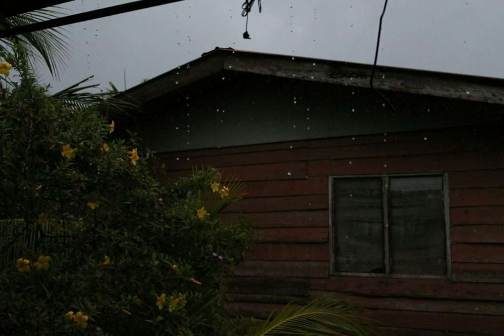Heavy rain pouring off a house roof during a storm